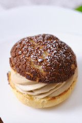 choux cream or cream puff or French profiteroles with fresh cream set on cafe table.