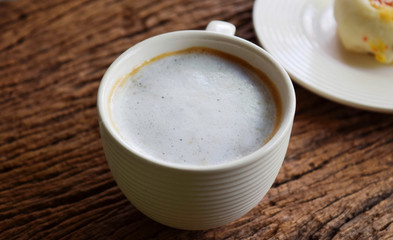 Hot coffee and spring roll on wooden table in the morning.