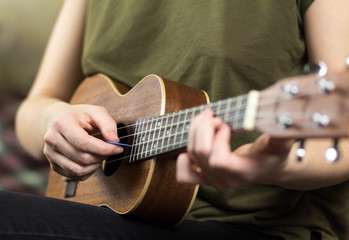 Fototapeta na wymiar Girl playing the ukulele. Close up. Isolated on white background
