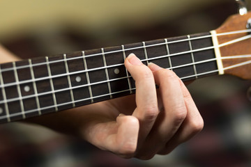 Fototapeta na wymiar Hand holding a chord on the ukulele. Close up. Isolated on white background