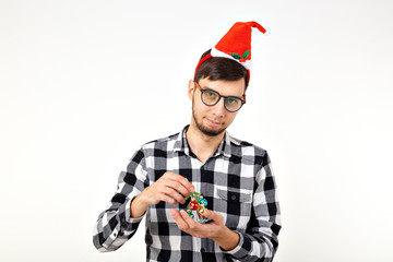 Holidays and presents concept - Funny emotional man in Christmas hat on white background with...