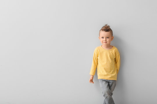 Portrait of cute little boy on light background