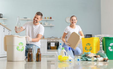 Couple sorting garbage at home. Concept of recycling