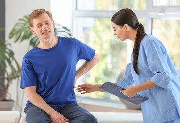 Obraz premium Physiotherapist working with male patient in rehabilitation center