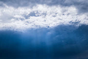 Fototapeta na wymiar Light beaming through a hole in the clouds