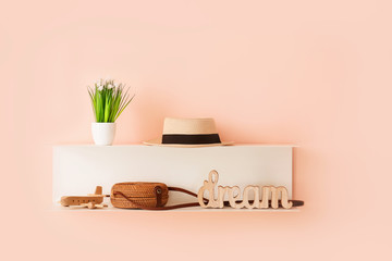 Shelf with female accessories hanging on color wall