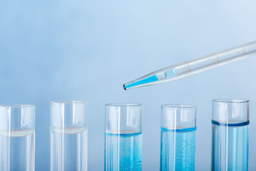 Dripping of color sample into test tube against color background