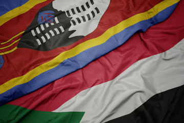 waving colorful flag of sudan and national flag of swaziland.