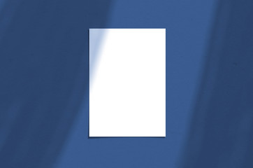 Blank white vertical paper sheet 5x7 inches with shadow overlay. Modern and stylish greeting card or wedding invitation mock up. Color of the year 2020 classic blue.