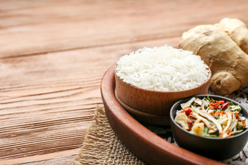 Obraz na płótnie Canvas Raw rice with dry vegetables and ginger on wooden table