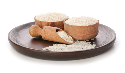 Bowls and scoop with raw rice on white background