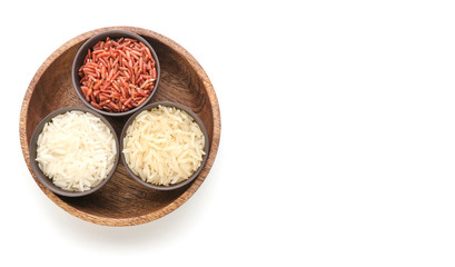 Bowls with raw rice on white background