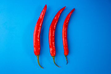A close up of red hot chili pepper over blue background.