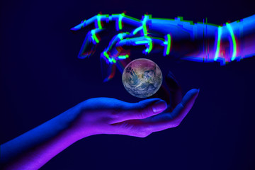 Earth between woman and robot's hands as symbol of partnership between people and technology for...