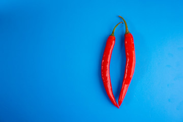 A close up of red hot chili pepper over blue background.