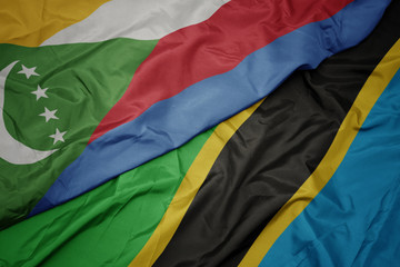 waving colorful flag of tanzania and national flag of comoros.