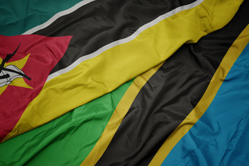 waving colorful flag of tanzania and national flag of mozambique.