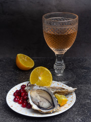Fresh oysters in plate, wine or champagne bottle, lemon, cranberries. Food background