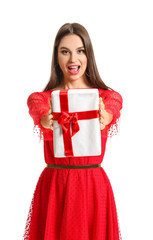 Fototapeta premium Beautiful young woman with Christmas gift on white background