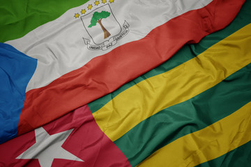 waving colorful flag of togo and national flag of equatorial guinea.