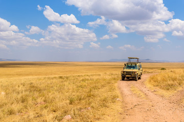 Safari tourists on game drive with Jeep car in Serengeti National Park in beautiful landscape scenery, Tanzania, Africa - obrazy, fototapety, plakaty
