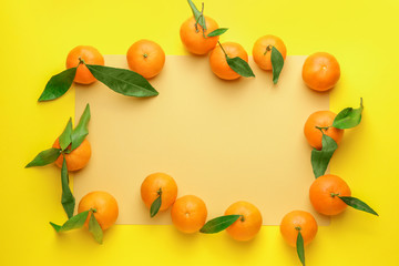 Frame made of sweet tangerines on color background