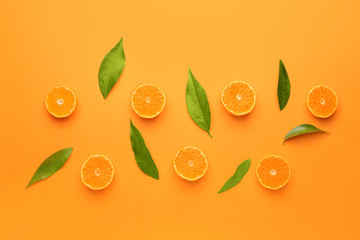 Pieces of sweet tangerines on color background