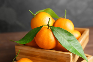Sweet tangerines in wooden box, closeup