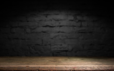 Wood table in front of rustic brick wall blur background with empty copy space on the table for product display mockup. Retro design montage presentation.