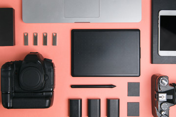 Flatley with tablet, camera and laptop. Minimalist layout of the photographer on a bright background.