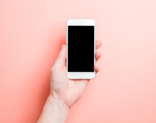 Minimalistic layout of the photographer. Hand with telephone on a pink background.