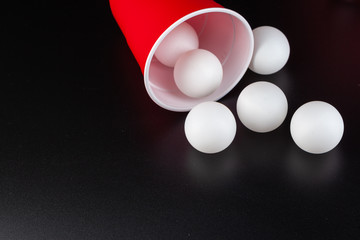 Red plastic cups and ball for game of beer pong