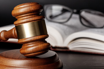 Wooden gavel and juridical books close up