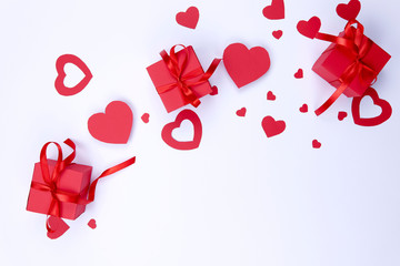 Valentine's day background.On a white background red hearts made of paper   and red boxes with a gift. A lot of free space. FLAT LAY STYLE.