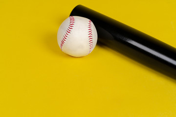 Baseball bat and ball on bright yellow background