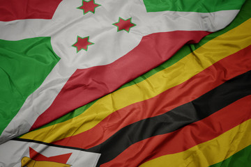 waving colorful flag of zimbabwe and national flag of burundi .