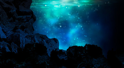 The depths of the sun through the water, the underwater world, the sea floor. Marine underwater landscape. Stones, corals, neon glow, reflection on the water. Night view.