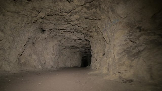 Speleology artificial cave dark tunnel excavation underground. Old adit for the extraction of metal and rocks