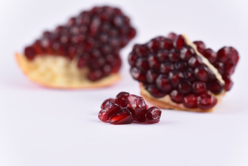 Pomegranate seeds on the white background close up
