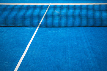 Blue paddle tennis net and court field background