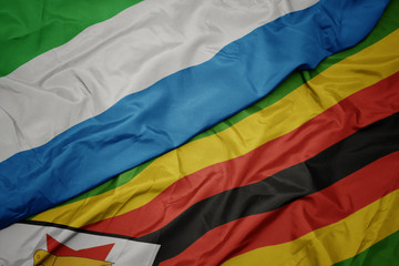 waving colorful flag of zimbabwe and national flag of sierra leone.