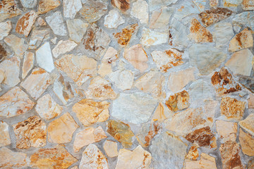 Masonry wall of stones with irregular pattern texture background