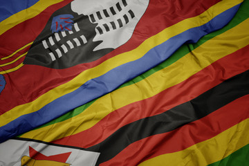 waving colorful flag of zimbabwe and national flag of swaziland.