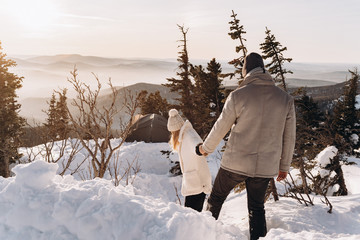 Couple in winter in the mountains at sunset