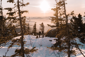 Couple in winter in the mountains at sunset