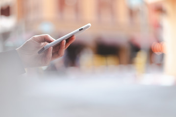 asian woman using smartphone with blurred city street as background