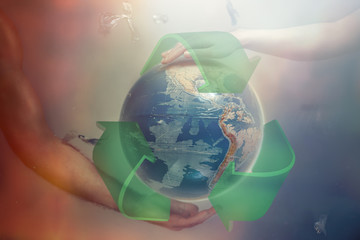 Women's and men's hands support the globe of planet Earth with sign of recycle. Around the flying plastic debris. The concept of preserving the earth's environment. Red and blue tint
