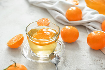 Cup of tea with sweet tangerines on table
