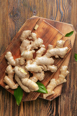 Boards with fresh ginger on wooden table