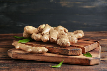 Boards with fresh ginger on wooden table
